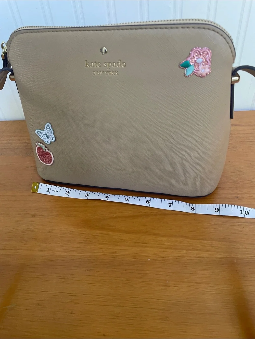 Kate Spade tan crossbody with floral, butterfly and fruit accents
